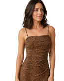 A woman wearing a brown leopard-print spaghetti-strap dress, shown from the waist up against a plain white background.