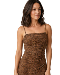 A woman wearing a brown leopard-print spaghetti-strap dress, shown from the waist up against a plain white background.