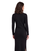Back view of a niffty black long-sleeve knit midi dress with a side slit on a model against a white background