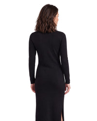 Back view of a niffty black long-sleeve knit midi dress with a side slit on a model against a white background