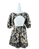 niffty Free People Dear Delilah mini dress featuring a black and beige floral print, puff sleeves, and open back.