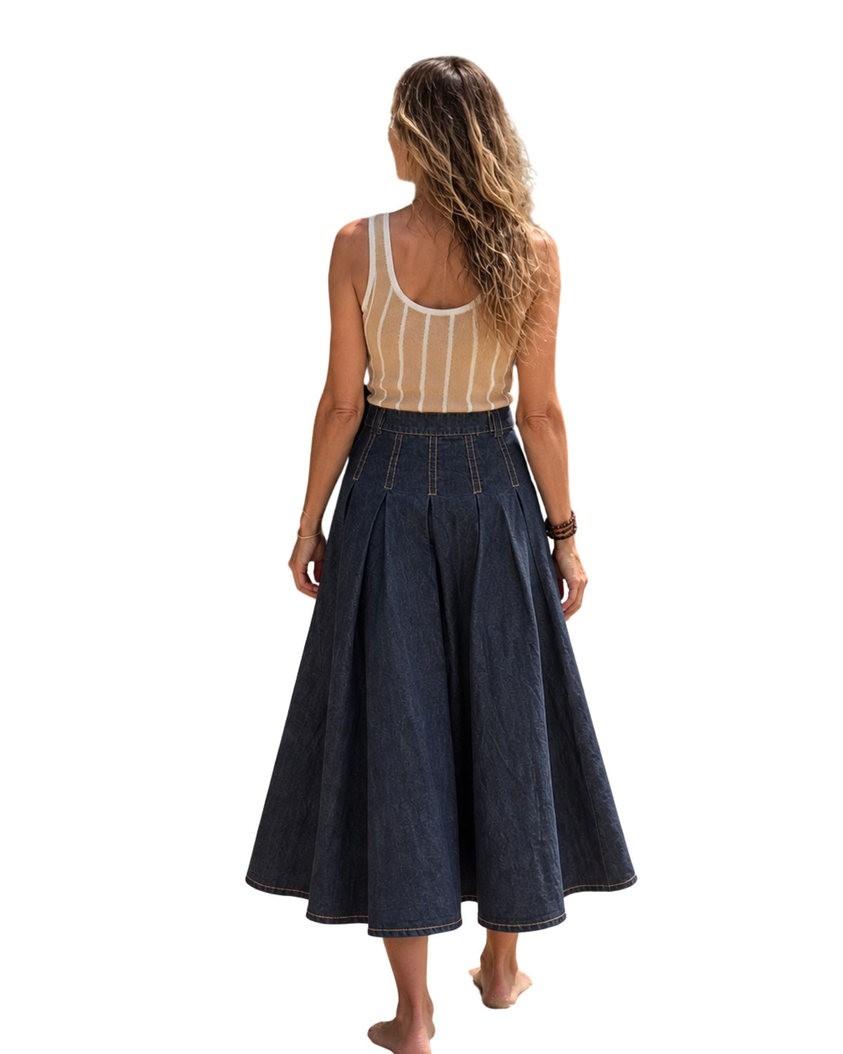 A woman wearing a niffty high-waisted pleated indigo denim midi skirt with contrast stitching, viewed from behind.