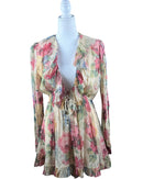 niffty Zimmermann silk romper in cream with pink and green floral print, featuring a deep V-neck and ruffled hems.